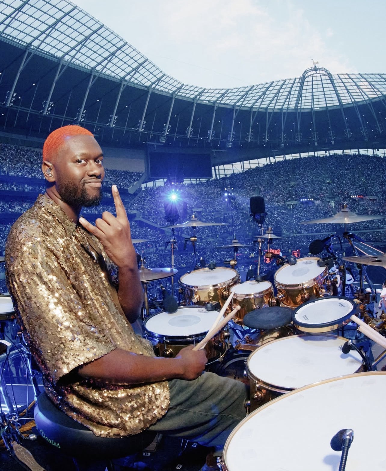 Diamond Johnson performing behind the drums in a packed arena